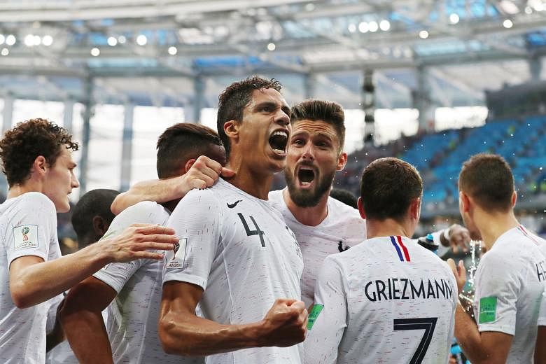 A delighted Raphael Varane celebrates with his team-mates after putting France ahead against Uruguay, who lacked bite with their striker Edinson Cavani left out after failing to recover from a calf injury.