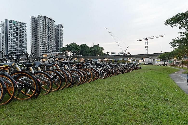 Rows of oBikes spotted at a field in Seng Kang early on Wednesday last week. Observers say the current dockless bike-share system - in which companies flood the market with two-wheelers and charge below-cost rates - is unsustainable.