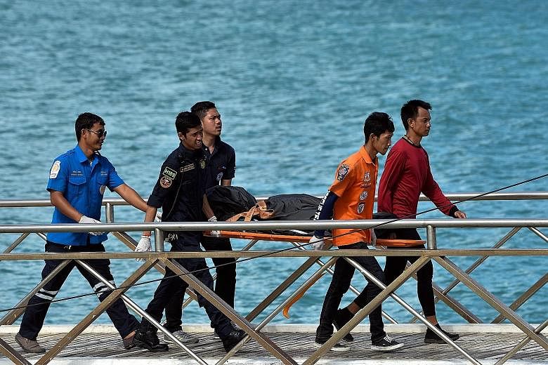 Thai rescue workers carrying the body of a victim on Friday. The Chinese government has pressed for a speedy investigation into the cause of Thursday's disaster, while Thai Deputy Prime Minister Prawit Wongsuwan has ordered a probe into why the boat'