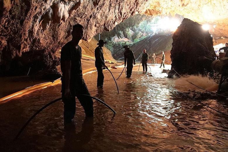 Thai navy divers inside the cave, in a photo released by the Royal Thai Navy. Rescuers have established a line to pump in fresh air and have withdrawn nonessential workers to preserve oxygen levels. Rescuers in the flooded cave in a photo released by