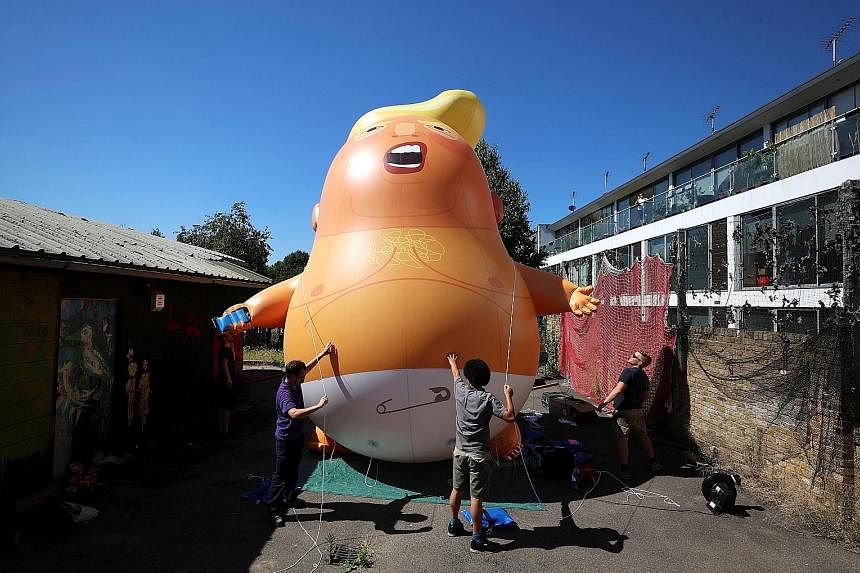 UK protesters inflate a blimp portraying US President Donald Trump which they plan to fly over Parliament during his visit.