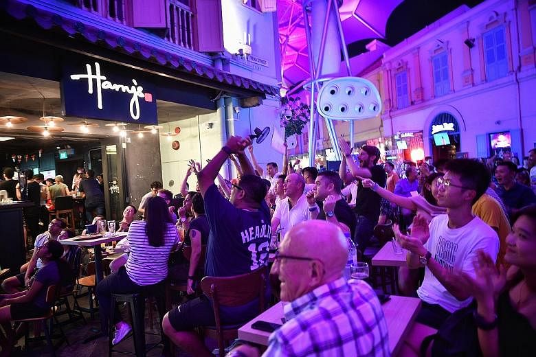 The crowd cheering at Harry's Bar in Clarke Quay during the World Cup quarter-final between Sweden and England yesterday. Fans watching the live screening of the match in comfort at the Resorts World Sentosa's Football Fever event.