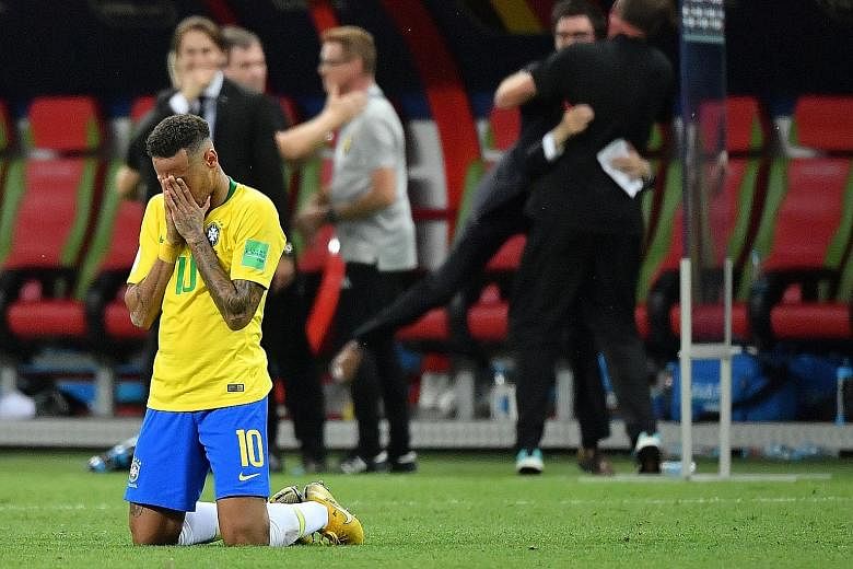 Brazil's goalkeeper Alisson fails to stop an own-goal by team-mate Fernandinho (17), while a distraught Neymar kneels and covers his face after his side are knocked out at the quarter-final stage on Friday. Many pundits believe Neymar's antics played