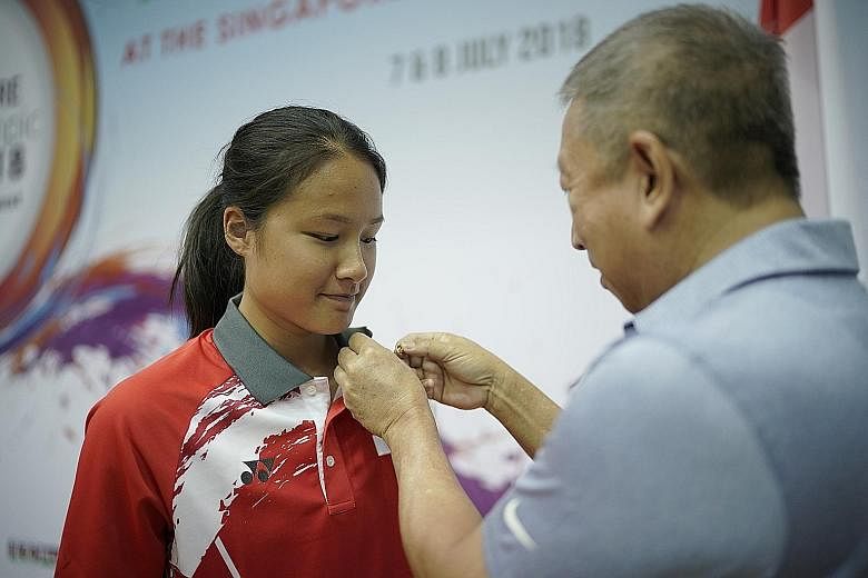 Short track speed skater Cheyenne Goh receiving the Olympic Participation Lapel Pin from Singapore Olympic Foundation chairman Ng Ser Miang at the opening ceremony of the 7th Singapore Youth Olympic Festival (SYOF) at the Toa Payoh Sports Hall yester