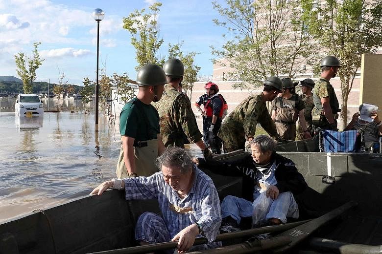 Staff and patients, some still in their pyjamas, being rescued from Kurashiki city's isolated Mabi Memorial Hospital in rowboats yesterday. A flooded area in Kurashiki, Okayama Prefecture, taken by Kyodo yesterday. The city with a population of just 