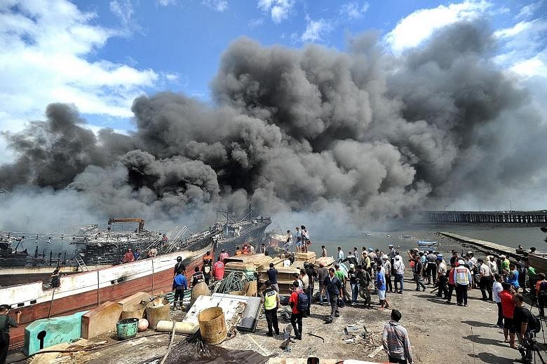 Workers and firefighters trying to extinguish a fire on fishing boats at Benoa harbour on Indonesia's resort island of Bali yesterday. The fire started after midnight and quickly engulfed nearly 40 local vessels but no injuries have been reported.