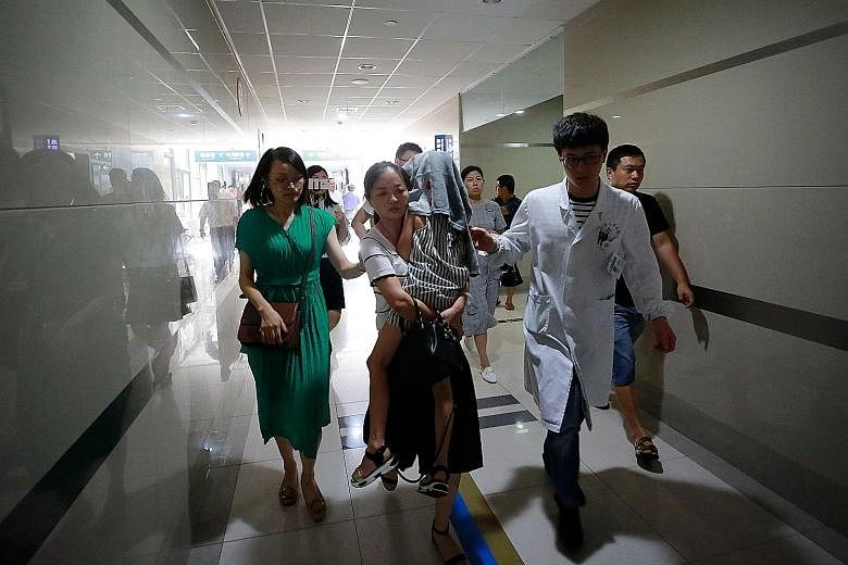 A child survivor of the capsized tourist boat in Thailand being carried into a hospital in China for treatment on Sunday. More than 40 people - mostly Chinese tourists - died in the incident and 11 remain missing.