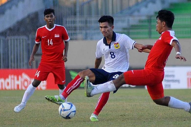 Singapore U-19 defender Nur Adam Abdullah tries to tackle Laos midfielder Chanthachone Thinolath in the Cubs' 5-0 defeat.
