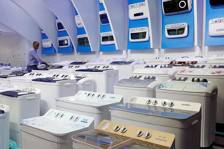 Washing machines at a fair in Guangzhou, China. Direct US tariffs affect a relatively small set of Singapore products - namely solar cells and modules, washing machines, steel and aluminium. These exports account for a "relatively modest" 0.1 per cen