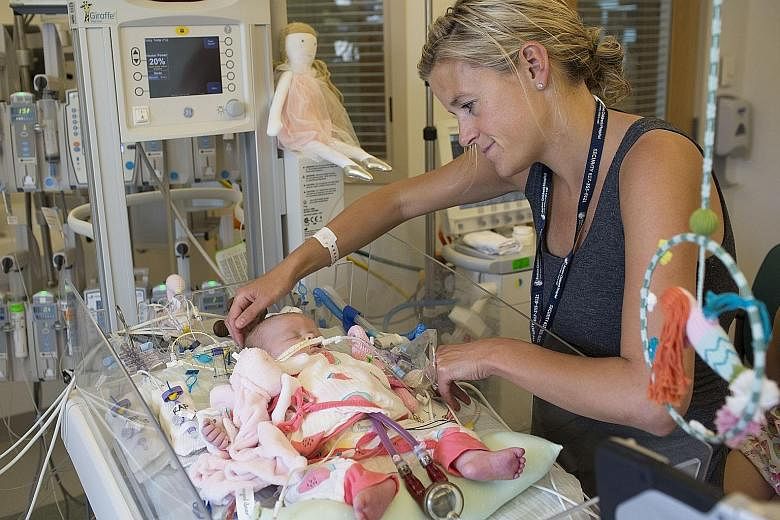 Ms Kate Bowen with her infant, Georgia, in the intensive care unit at Boston Children's Hospital last month. Georgia had had a heart attack, most likely while she was still in the womb, and her heart was profoundly damaged. Doctors tried to revive he
