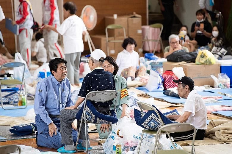 Japan's Prime Minister Shinzo Abe yesterday visited a centre for people displaced by the recent flooding in Mabi, Okayama prefecture.