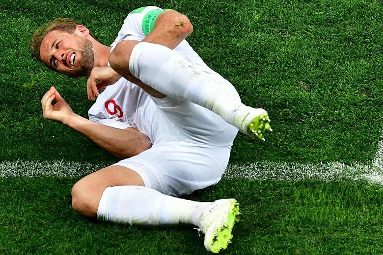 Left: Striker Harry Kane on the ground after being tackled during the semi-final against Croatia on Wednesday at the Luzhniki Stadium in Moscow. The England captain admitted that the defeat "will hurt for a while" but insisted he was proud. Below: Ki