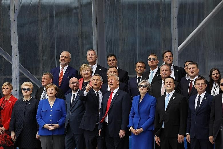 Nato secretary-general Jens Stoltenberg standing beside US President Donald Trump as they and other leaders watch a military aerial display at the Nato summit in Brussels, Belgium, on Wednesday.
