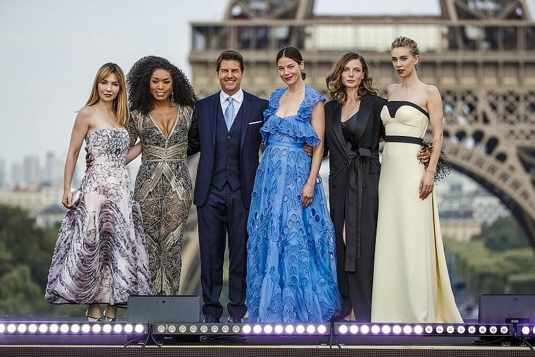 American actor Tom Cruise and his fellow Mission: Impossible - Fallout cast members (from far left) Alix Benezech, Angela Bassett, Michelle Monaghan, Rebecca Ferguson and Vanessa Kirby in front of the Eiffel Tower at the film's world premiere in Pari