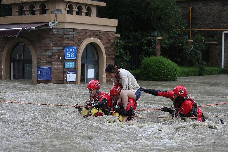 Right: A flooded village in Zoige county, in the south-western province of Sichuan, on Friday. Far right: Firefighters rescuing a stranded woman, following heavy rainfall in Chengdu, in Sichuan province. Left: A landslide hit a township in Zhouqu cou