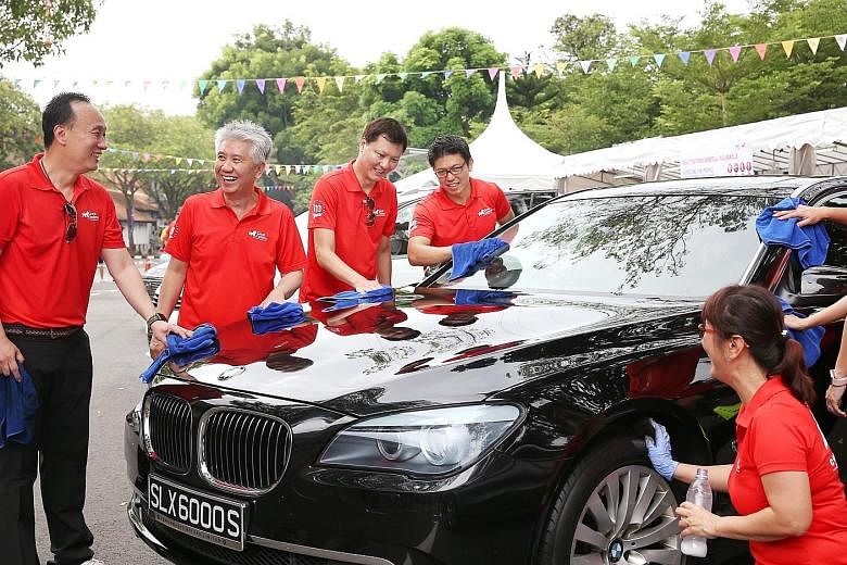 Great Eastern group chief executive Khor Hock Seng (second from left) was among 170 staff from the company who rolled up their sleeves to wash cars yesterday - all in the name of charity. They raised more than $60,000 for The Straits Times School Poc