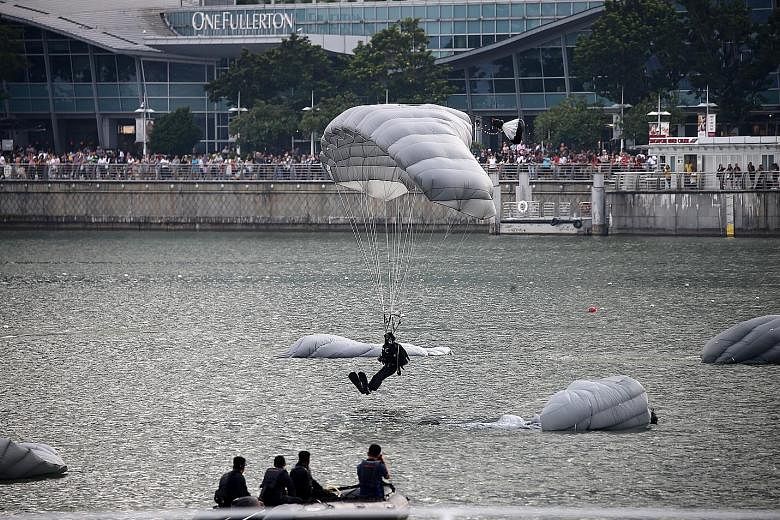 Eight divers from the Republic of Singapore Navy's Naval Diving Unit doing their first freefall water jump into Marina Bay yesterday. They have to carry gear weighing 50kg and wear dive fins during their drop from a Super Puma helicopter at a height 