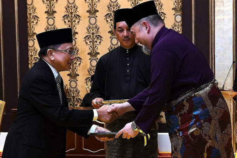 Malaysia's King, Sultan Muhammad V, handing the Chief Justice appointment letter to Tan Sri Richard Malanjum at Istana Negara last Wednesday.