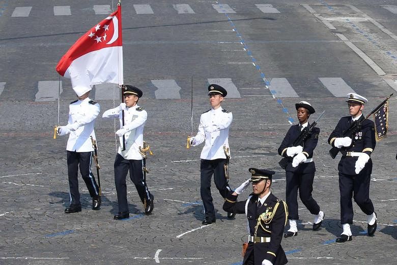 Above: Singapore's Flag Party, led by Contingent Commander Major Nicholas Tong Jun, carrying the Republic's flag at the parade. Left: A combined flypast involving an RSAF M-346 Advanced Jet Trainer and five French Air Force Alpha Jets. Prime Minister