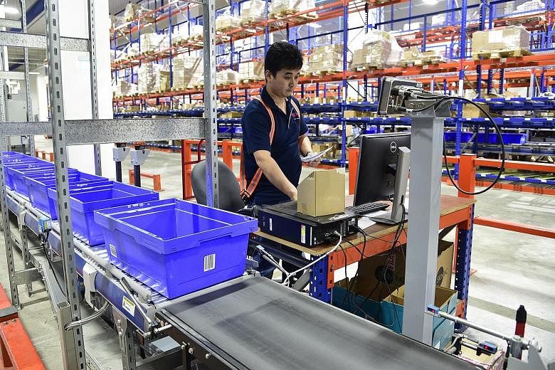 Couriers from SP Parcels check a parcel before it is placed in a delivery van. Speedpost is a last mile door-to-door express delivery service by SP Parcels, a subsidiary of SingPost. Couriers loading parcels containing customers' orders onto delivery