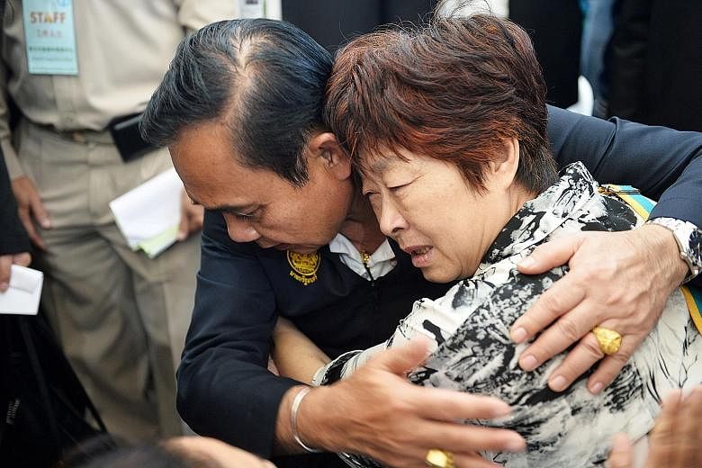 Thai Prime Minister Prayut Chan-o-cha comforting the relative of a victim of the Phuket boat accident.