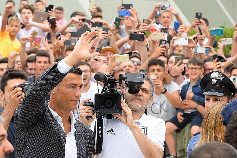 Cristiano Ronaldo waving to Juventus fans as he arrived at the club's medical centre in Turin, Italy yesterday. He will earn a reported €30 million (S$47.9 million) a season.
