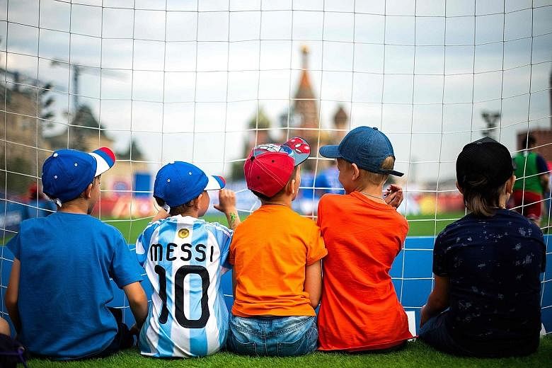 Left: Young fans watching a friendly amateur match between France and Croatia at the Red Square in Moscow as football fever swept across the nation during the World Cup. Below: The hosts defied expectations and knocked Spain out in a penalty shoot-ou