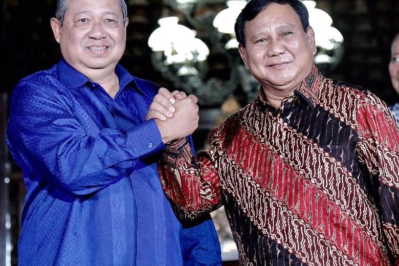 Above: Dr Susilo Bambang Yudhoyono (in blue shirt) and Mr Prabowo Subianto are set to meet tonight to discuss joining forces, sources say, amid rumours that Mr Prabowo has invited Dr Yudhoyono's eldest son Agus Harimurti Yudhoyono (left) to be his ru