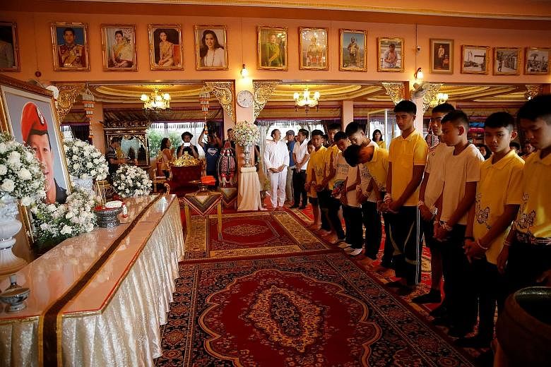 Some of the boys rescued from the Tham Luang cave complex paying their respects to former navy Seal diver Saman Gunan, who lost his life during the rescue operation, at Mae Sai's Wat Pha That Doi Wao temple in Chiang Rai province yesterday.