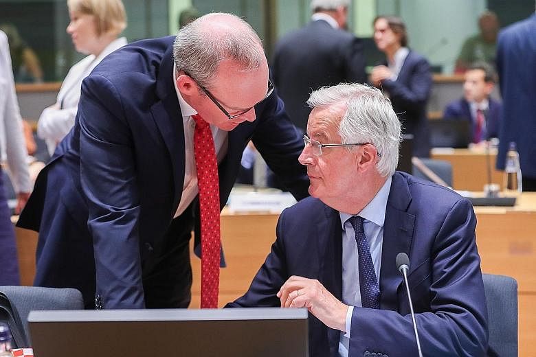 The European Union's chief Brexit negotiator, Mr Michel Barnier (seated), with Irish Minister for Foreign Affairs and Trade Simon Coveney before the General Affairs Council meeting at the European Council in Brussels yesterday.