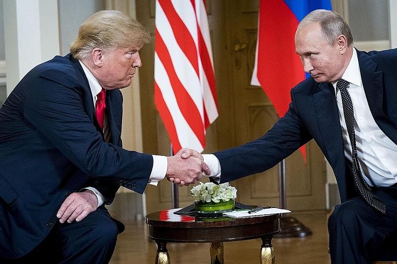 US President Donald Trump meeting President Vladimir Putin of Russia in Helsinki on Monday. The US' top intelligence official is still groping for details of what the two leaders had discussed. Mr Trump speaking to the press during a meeting with mem