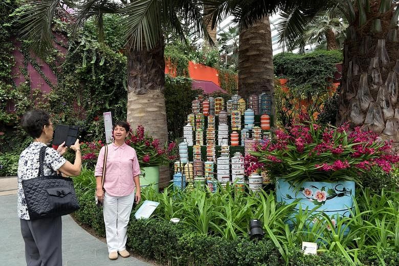More than 14,000 orchids of 120 varieties are showcased amid tingkat carriers (above) and shophouse facades at the Orchid Extravaganza. Its creative director is Singaporean film-maker Royston Tan (left).