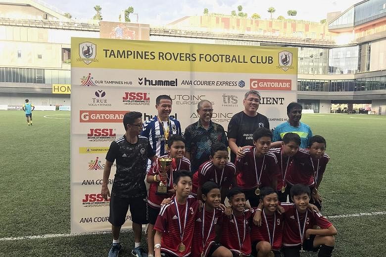 Mr Masagos Zulkifli (centre), Minister for the Environment and Water Resources, after presenting the trophy to players from the Star Soccer Academy who were crowned champions of an Under-12 football festival celebrating Singapore's Racial Harmony Day