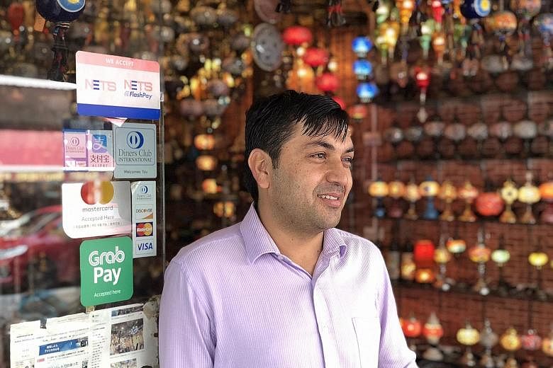 Mr Faizullah Saadullah operates family-owned retail shop Sufi Trading, which has used the GrabPay platform for three months and adopted Alipay recently. Mr Faizullah says the Alipay platform allows the Arab Street shop, which sells Turkish lamps, han