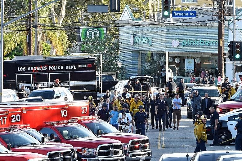 Police and fire department personnel outside a Trader Joe's supermarket (above) in Silverlake, Los Angeles, yesterday, after a man involved in a shooting barricaded himself there and took about 40 people hostage. A Trader Joe's employee (below) being