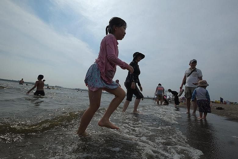 People on the beach of a seaside park in Tokyo yesterday. Japan's severe heatwave has killed at least 15 people and sent more than 12,000 to hospital in the first two weeks of this month.