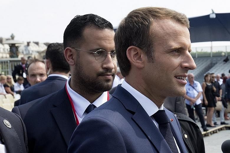 Alexandre Benalla seen with Mr Emmanuel Macron on Bastille Day. A video shows the aide allegedly wearing a riot helmet and police uniform and attacking protesters in May.