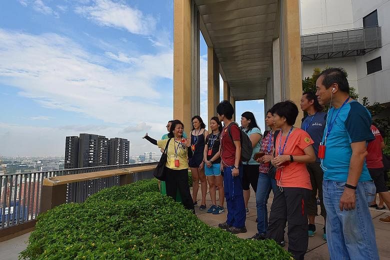 Ms May Hui, 64, a volunteer guide from My Community, leading a group on the heritage walk at the rooftop of Skyville@Dawson yesterday. My Community has a pool of about 150 volunteers who lead participants on the tours.