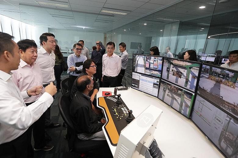 Transport Minister Khaw Boon Wan (second from left) and Dr Lam Pin Min (third from left), Senior Minister of State for Transport, were briefed at the Automated Crane Operations Centre on the new automated quay crane system at the Pasir Panjang Termin