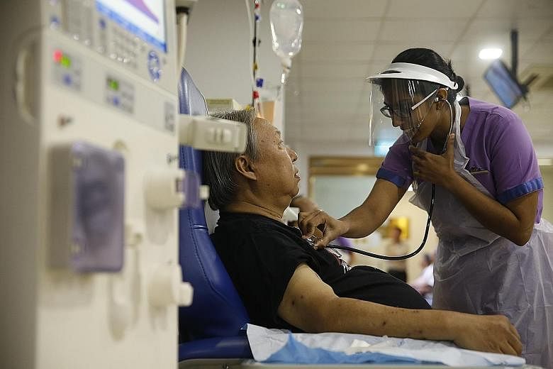 Staff nurse Saraswathy Govintharaju checking Mr Bob Chua before the dialysis treatment is administered. Now, aged 60, he can no longer travel easily, has had to turn down dinner invitations and must put up with two thick needles being poked into his 