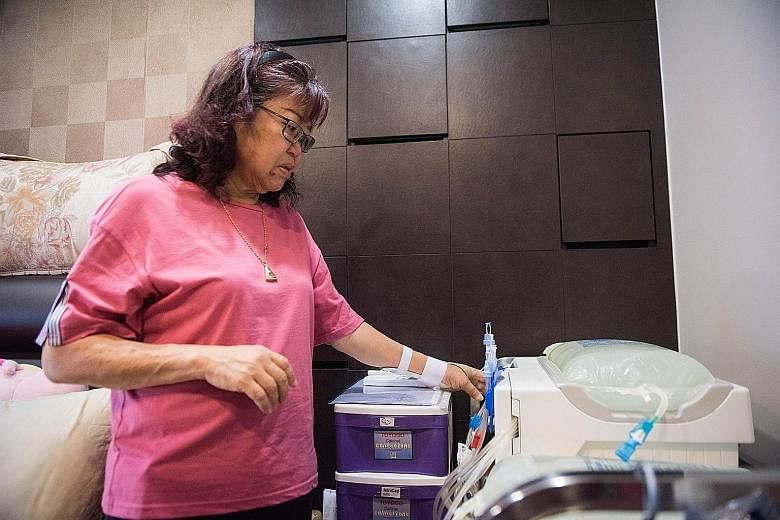 Madam Ivy Tan replacing the peritoneal dialysis solution at home. She opted for peritoneal dialysis when her kidneys stopped functioning, and, with the aid of a machine, she does the dialysis overnight over an eight-to 10-hour period every day.