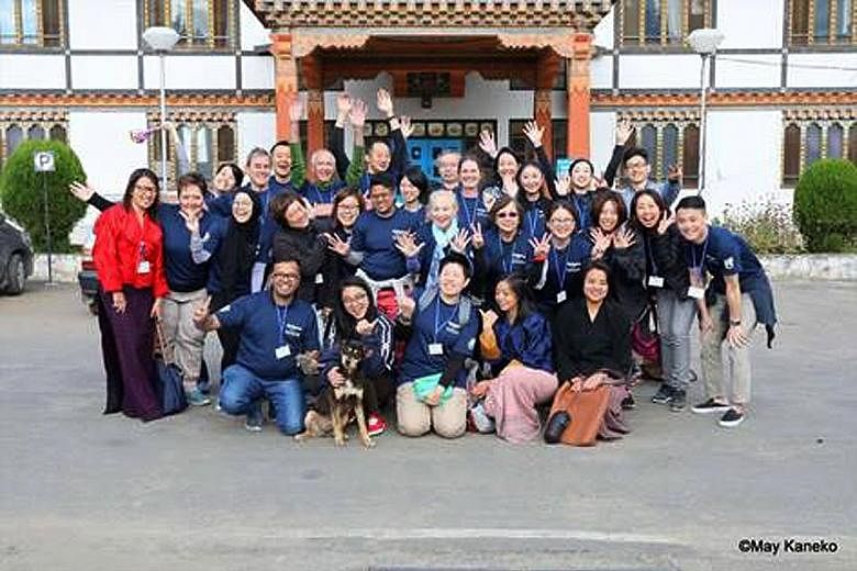 Above: Volunteers from Bhutan, China, India, Japan, Singapore, Britain and the US on Smile Asia's Screening Day outside Paro Hospital, Bhutan, in October 2016. Left: Eight-month-old Tandin Tshomo with her mother, Ms Sangay Lhamo, 19, and father, Mr S