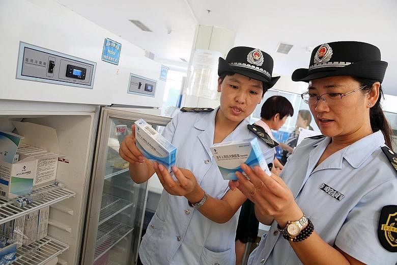 China Food and Drug Administration officials checking rabies vaccines at the Disease Control and Prevention Centre in Anhui province yesterday. The Chinese authorities are scrambling to defuse public outrage over a safety scandal involving vaccines.