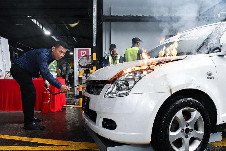 Managing director Kenneth Lim of Lingjack Engineering Works showing how to use the foam-mist fire extinguisher, which has an extended muzzle for the user to safely put out engine fires without opening the vehicle bonnet. Vicom is using Lingjack's new