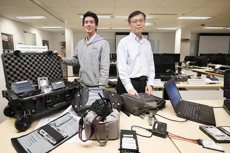 CSA National Cyber Incident Response Centre director Dan Yock Hau (right) and CSA senior consultant Lin Weiqiang with the forensic toolkits used to gather evidence at SingHealth's premises on the day of the attack. The equipment allows investigators 