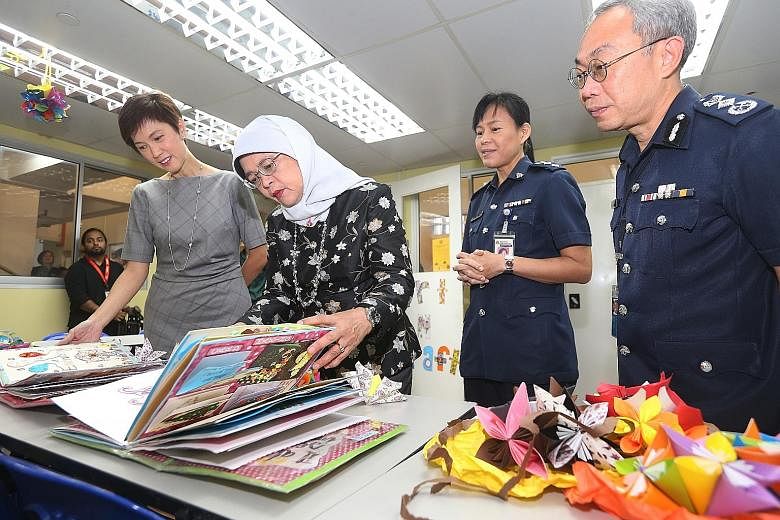 President Halimah Yacob and Second Minister for Home Affairs Josephine Teo looking at artwork made by some of the female inmates. With them are Superintendent of Institution A4 Lam Mong Teng and Commissioner of Prisons Desmond Chin.