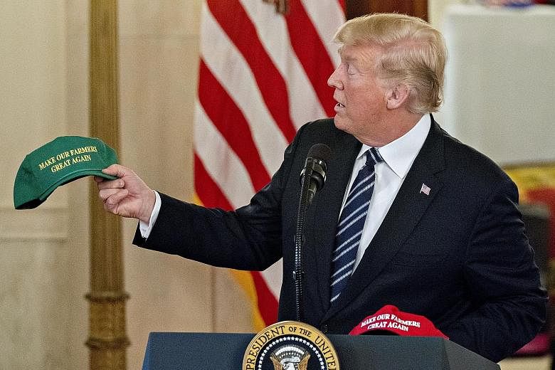 President Donald Trump with a "Make Our Farmers Great Again" cap while speaking at a Made in America products showcase in the Cross Hall of the White House on Monday.