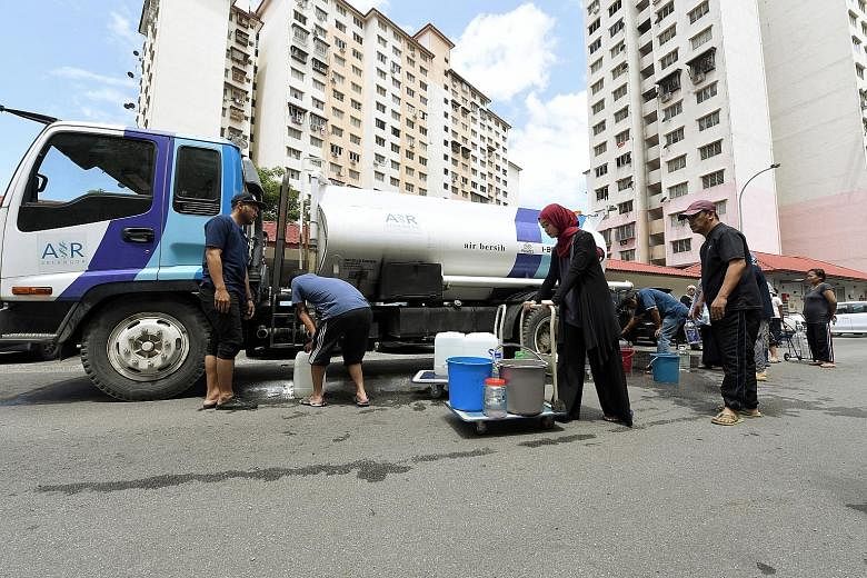 Residents of a Kuala Lumpur apartment block collecting water from a tank after supply was disrupted on March 11. Under a 2006 Act to centralise water infrastructure under the federal government, firms holding water concessions are to sell their asset