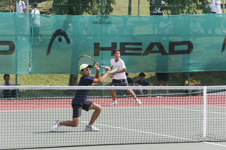 Top: The ACS (I) doubles pair of Aaron Chiu (in blue) and Matthias Wong during their 6-4, 6-3 win over ACS (Barker Road)'s Luke Eng and Martin Lim yesterday. Above: The ACS (I) boys celebrate reclaiming the C Division title they last won in 2016.