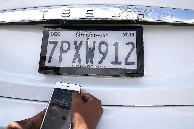 Mr Alok Damireddy uses a smartphone app to adjust a digital licence plate made by Reviver Auto. The plates are being tested under a pilot programme in California.